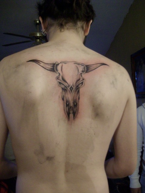 Black Ink Cow Skull Tattoo On Man Upper Back