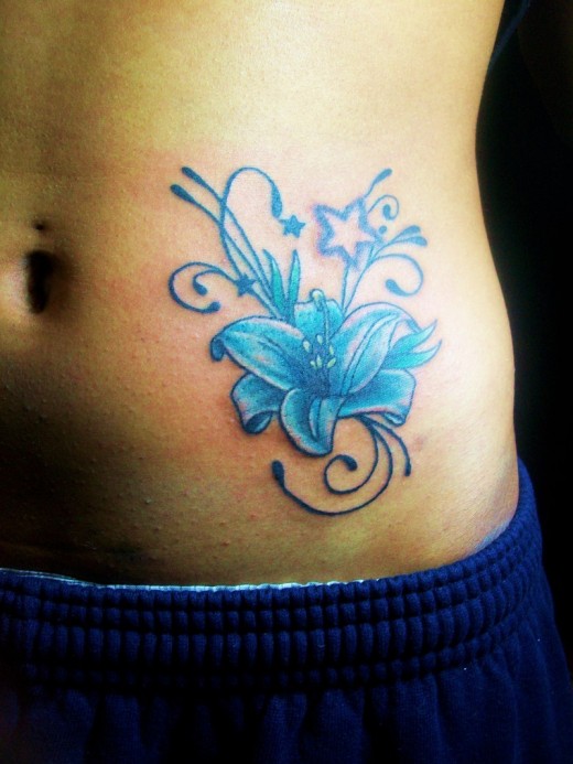 Blue Ink Flower With Star Tattoo On Side Belly