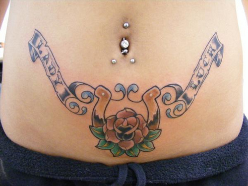 Flower With Horseshoe With Banner Tattoo On After Pregnancy Belly
