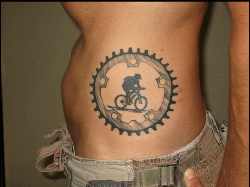 Man Riding Bike In Gear Tattoo On Side Rib