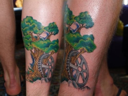 Tree With Bike Wheel Tattoo On Couple Leg Calf