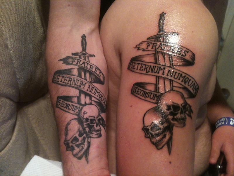 Sword In Two Army Skull With Banner Tattoo On Forearm And Shoulder