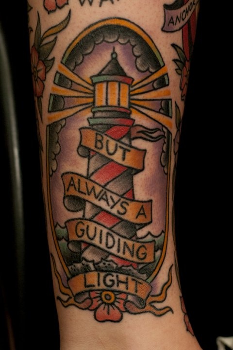But Always A Guiding Light Banner On Lighthouse Tattoo On Forearm