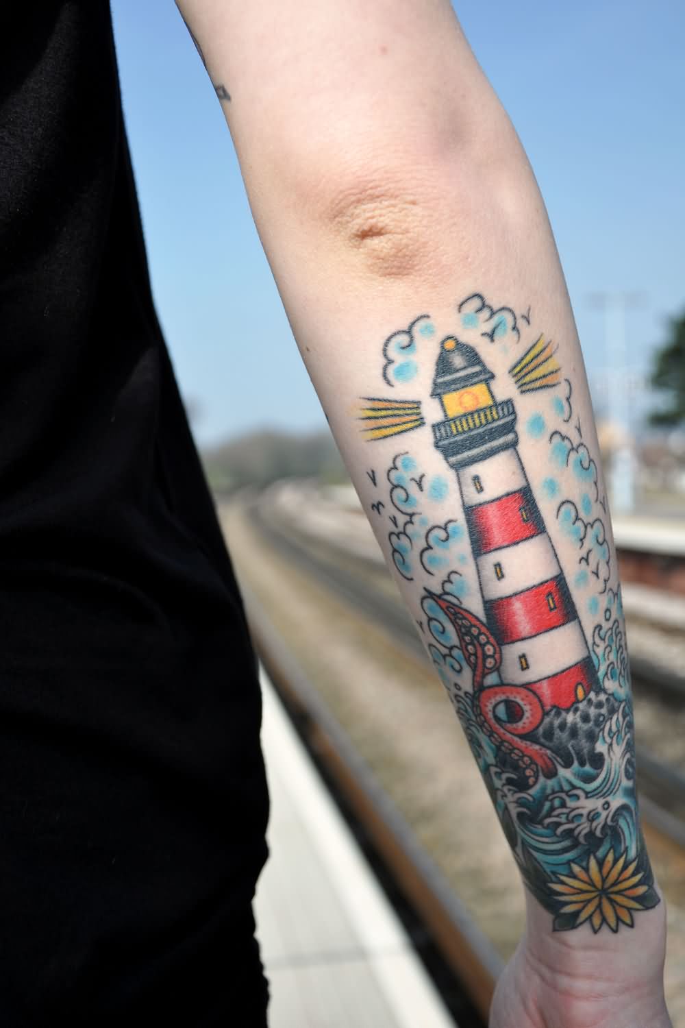 Color Flowers And Lighthouse Tattoos On Forearm