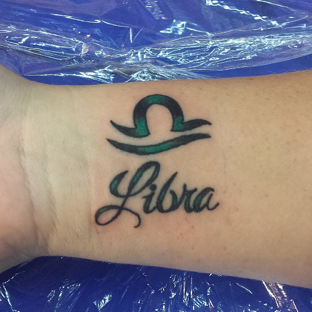 Green And Black Ink Libra Tattoo On Wrist