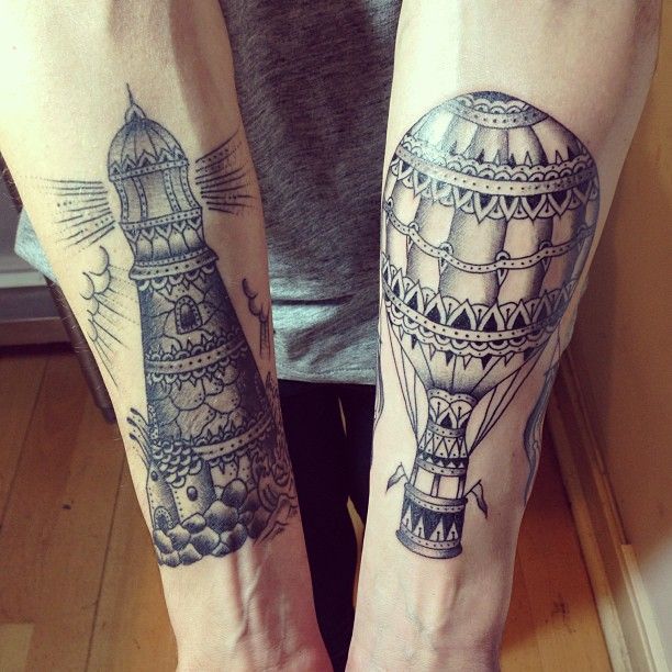 Grey Ink Parasute And Lighthouse Tattoos On Forearm