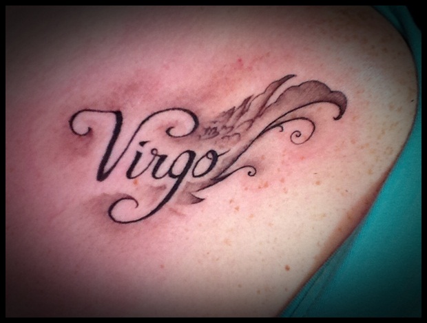 Grey Ink Virgo Tattoo On Collarbone