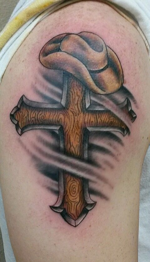 Ripped Skin Cross With Cowboy Hat Tattoo On Shoulder