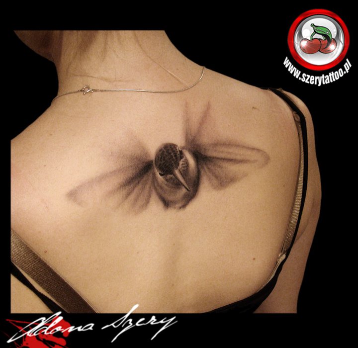 Black And Grey Flying Hummingbird Tattoo On Girl Upper Back