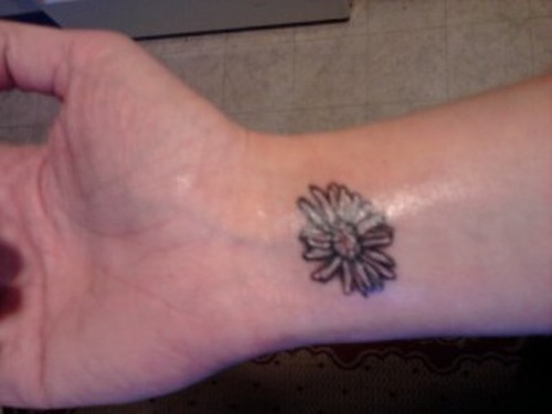 Black Ink Daisy Flower Tattoo On Wrist