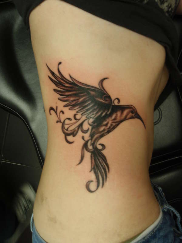 Black Ink Flying Hummingbird Tattoo On Side Rib