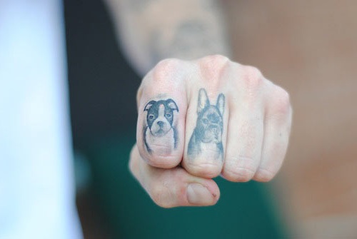 Black Ink Two Dog Face Tattoo On Finger