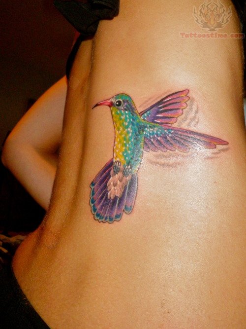 Colorful Flying Hummingbird Tattoo On Side Rib