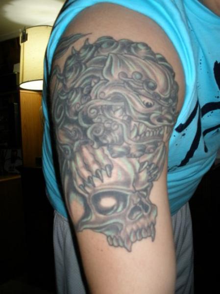 Foo Dog With Skull Tattoo On Man Right Half Sleeve
