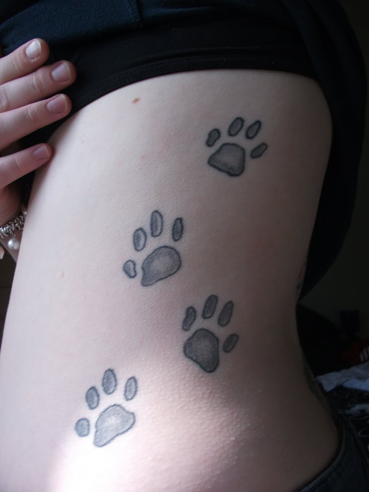 Four Dog Paw Print Tattoo On Side Rib.