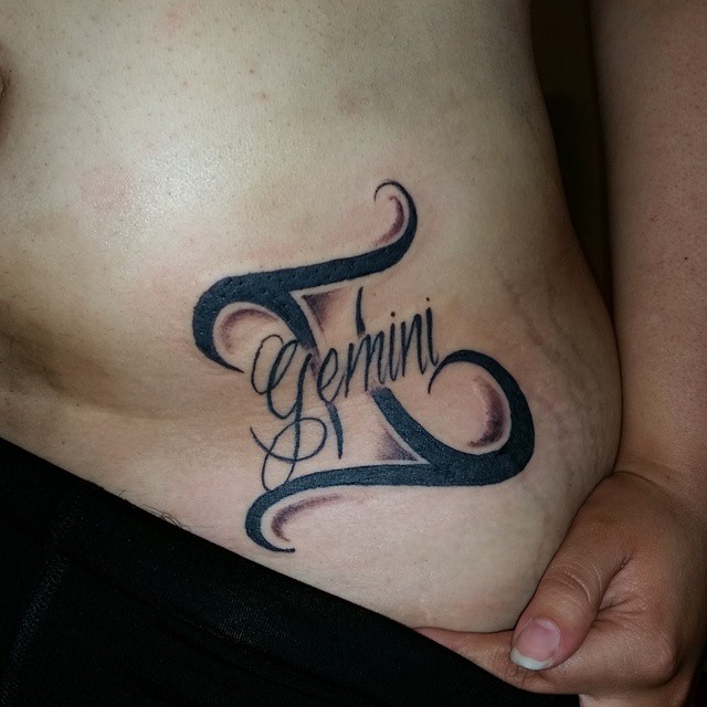 Girl Showing Her Gemini Zodiac Tattoo On Waist
