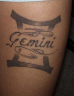 Grey Ink Gemini Tattoo On Bicep