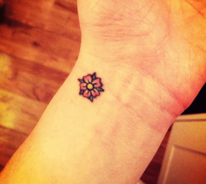 Pink Ink Little Daisy Flower Tattoo On Wrist