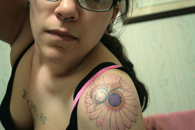 Snail With Daisy Tattoo On Girl Left Shoulder