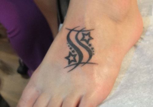 Stars And Tribal Gemini Tattoo On Left Foot