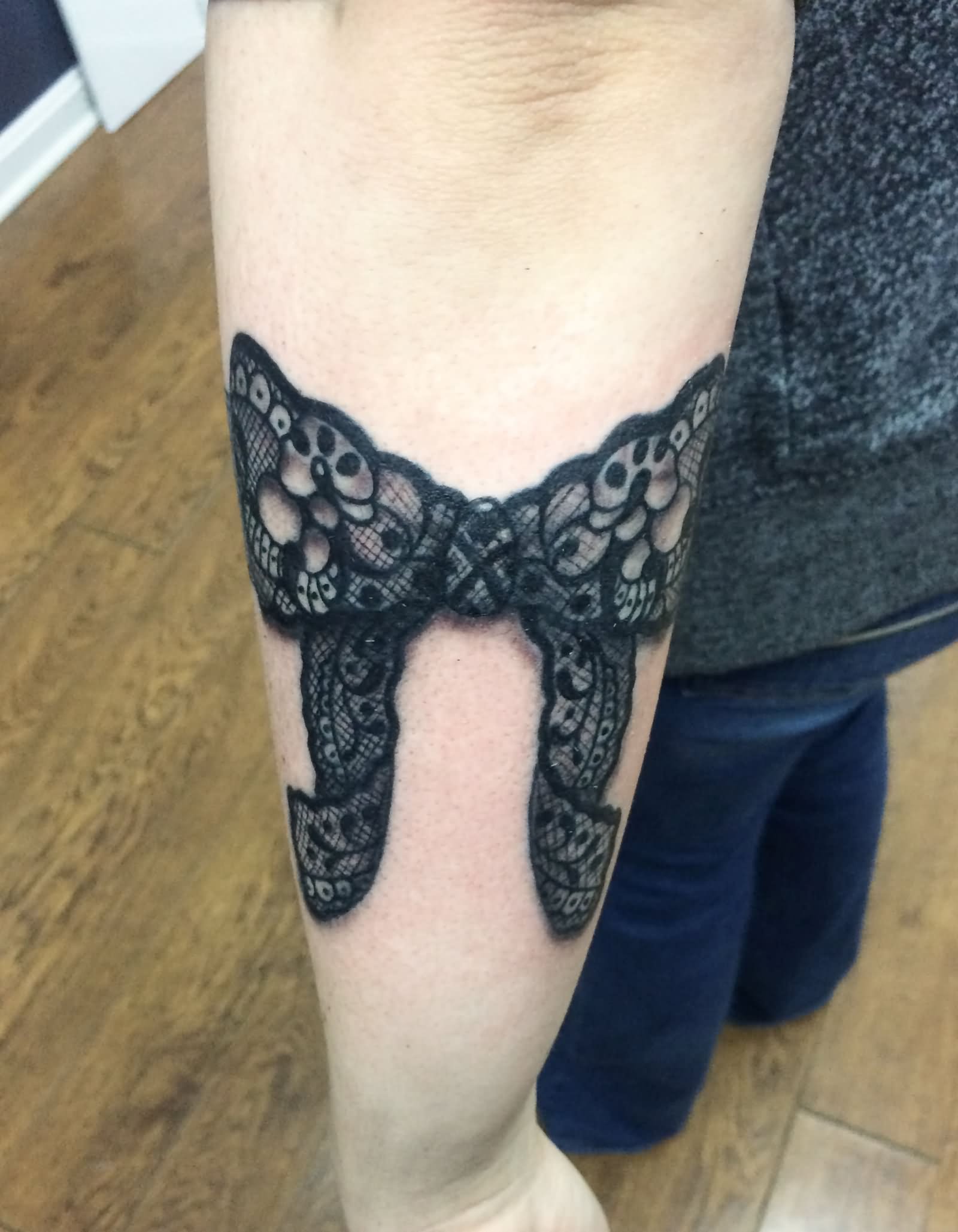Black Lace Ribbon Bow Tattoo On Left Forearm