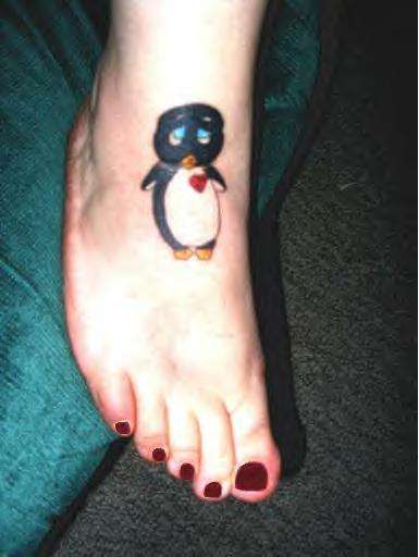 Girl Showing Her Penguin Tattoo On Foot