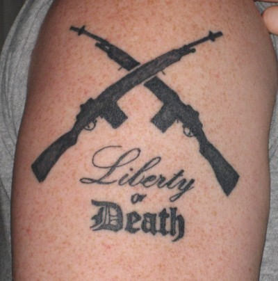 Liberty Or Death - Two Crossing Guns Tattoo Design For Shoulder