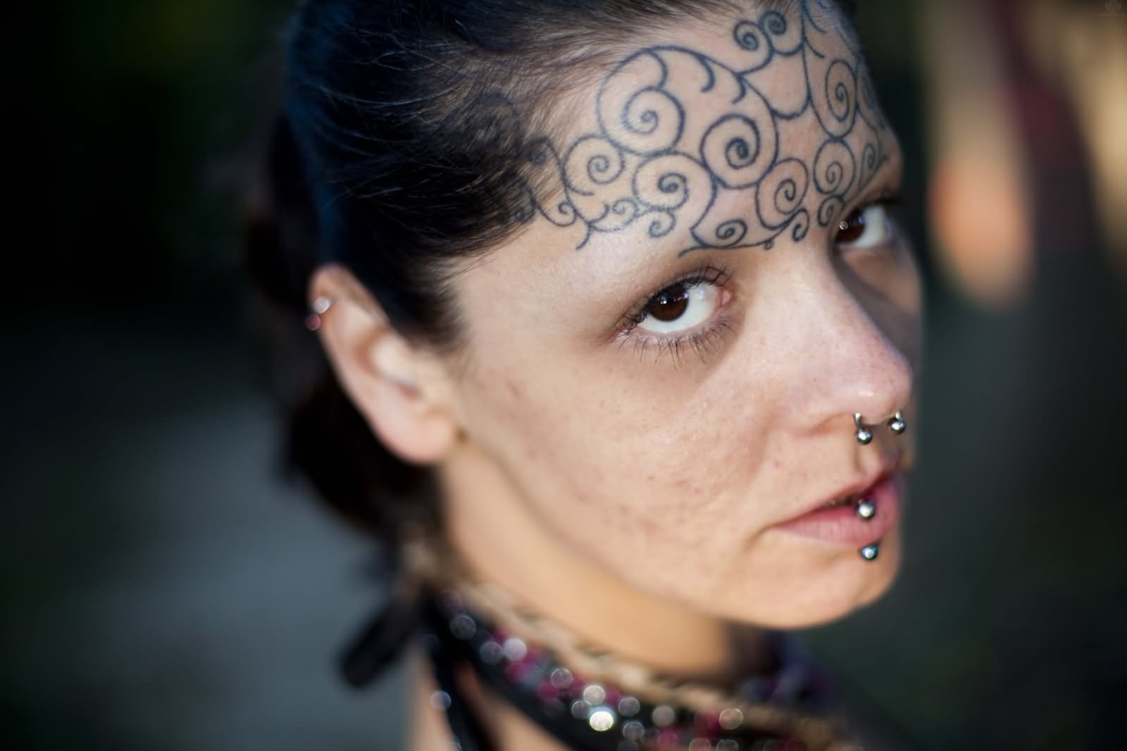 Nice Black Spiral Forehead Tattoo For Girls