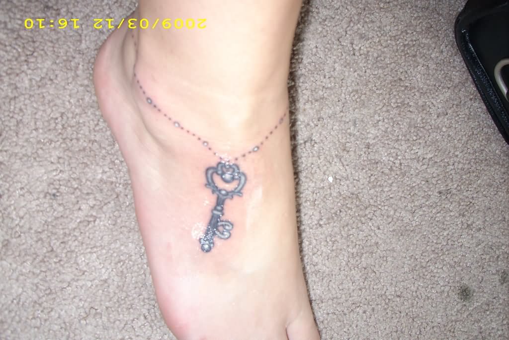 Simple Black And Grey Rosary Key Tattoo On Foot