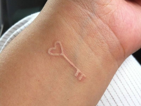 Simple White Ink Heart Key Tattoo On Wrist