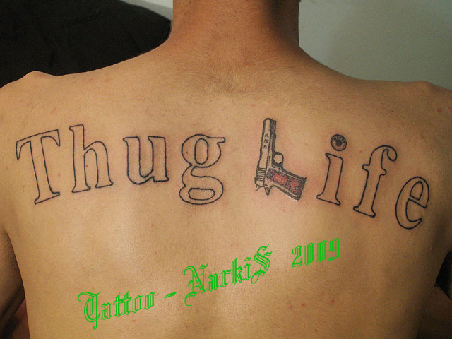 Thug Life Lettering With Gun Tattoo On Upper Back