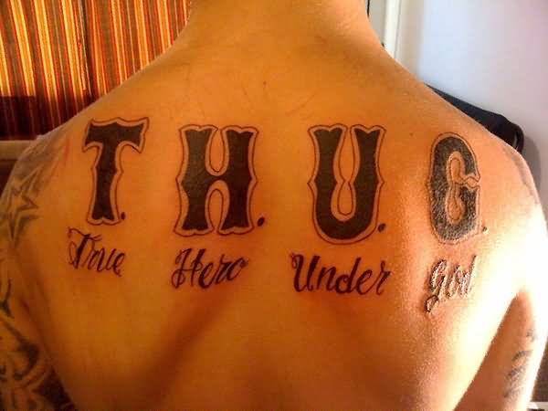 Thug True Hero Under God Lettering Tattoo On Upper Back