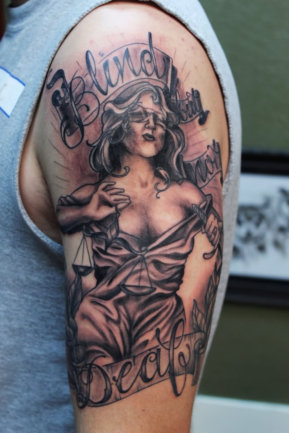 Black Ink Blind Lady Justice With Banner Tattoo On Left Half Sleeve