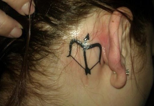 Black Ink Bow And Arrow Sagittarius Tattoo Behind Ear