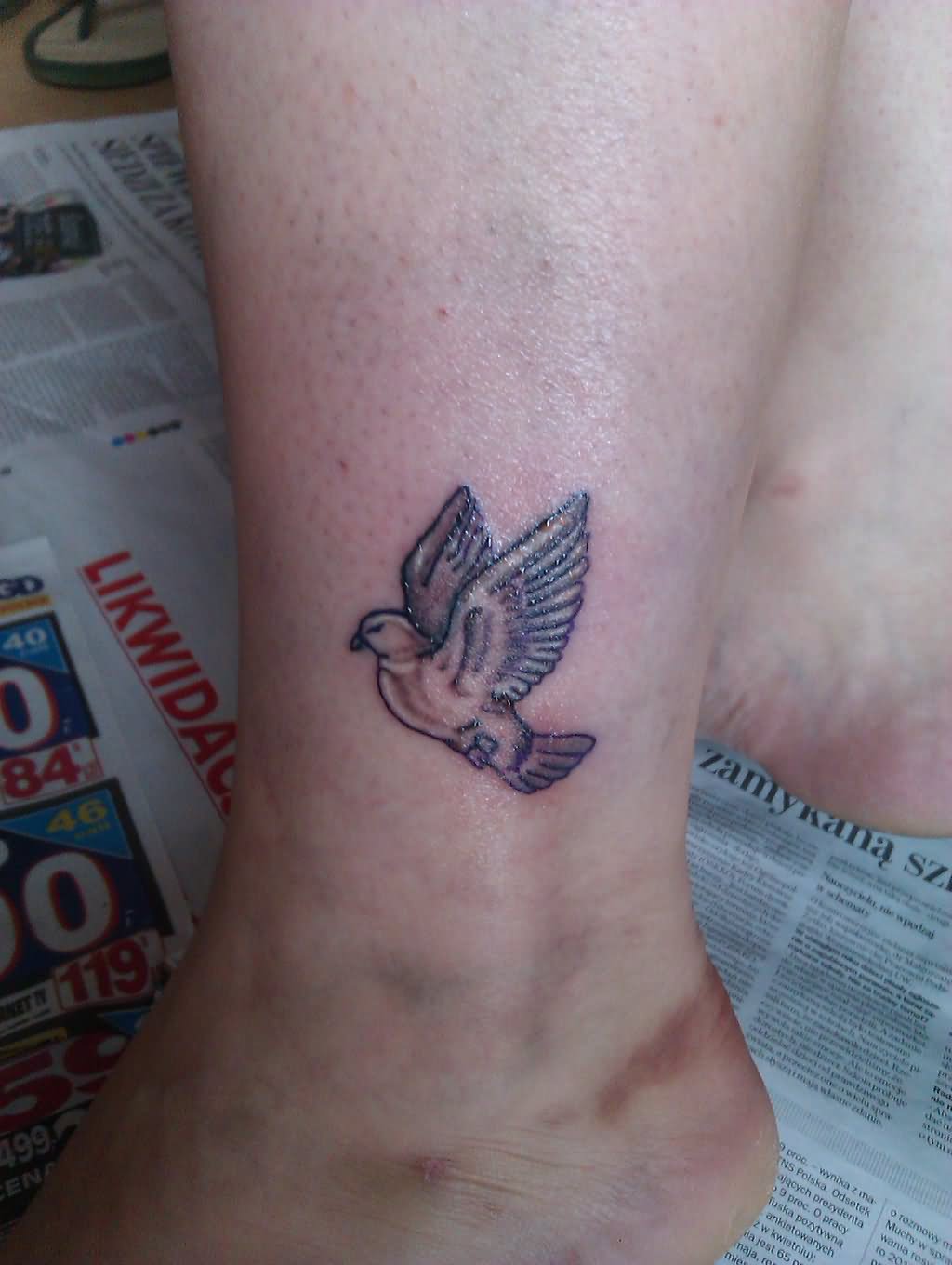 Black Ink Little Flying Pigeon Tattoo On Leg