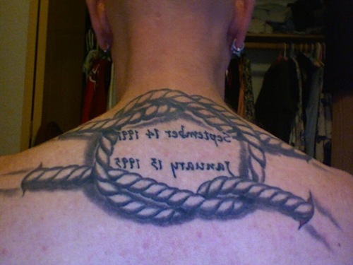 Black Ink Rope Knot Tattoo On Man Upper Back