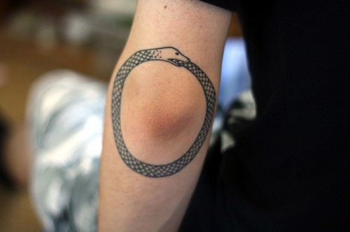 Black Ouroboros Tattoo On Left Elbow