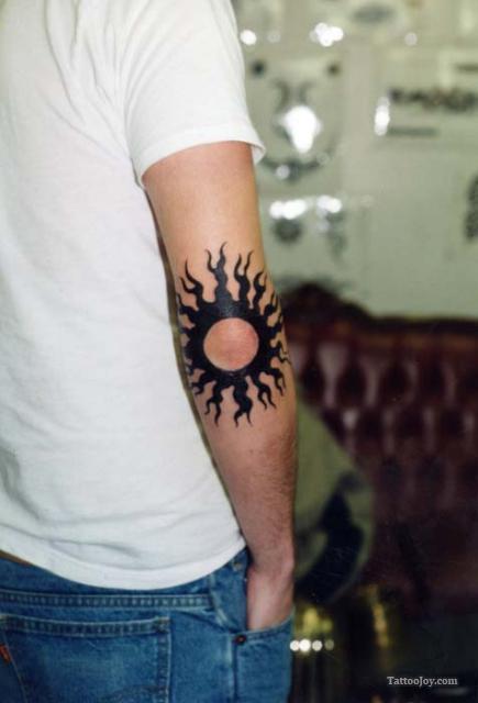 Black Tribal Sun Tattoo On Man Right Elbow