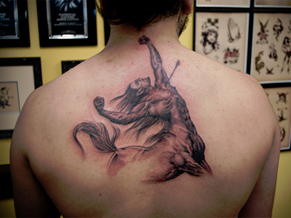 Grey Ink Sagittarius Tattoo On Man Upper Back