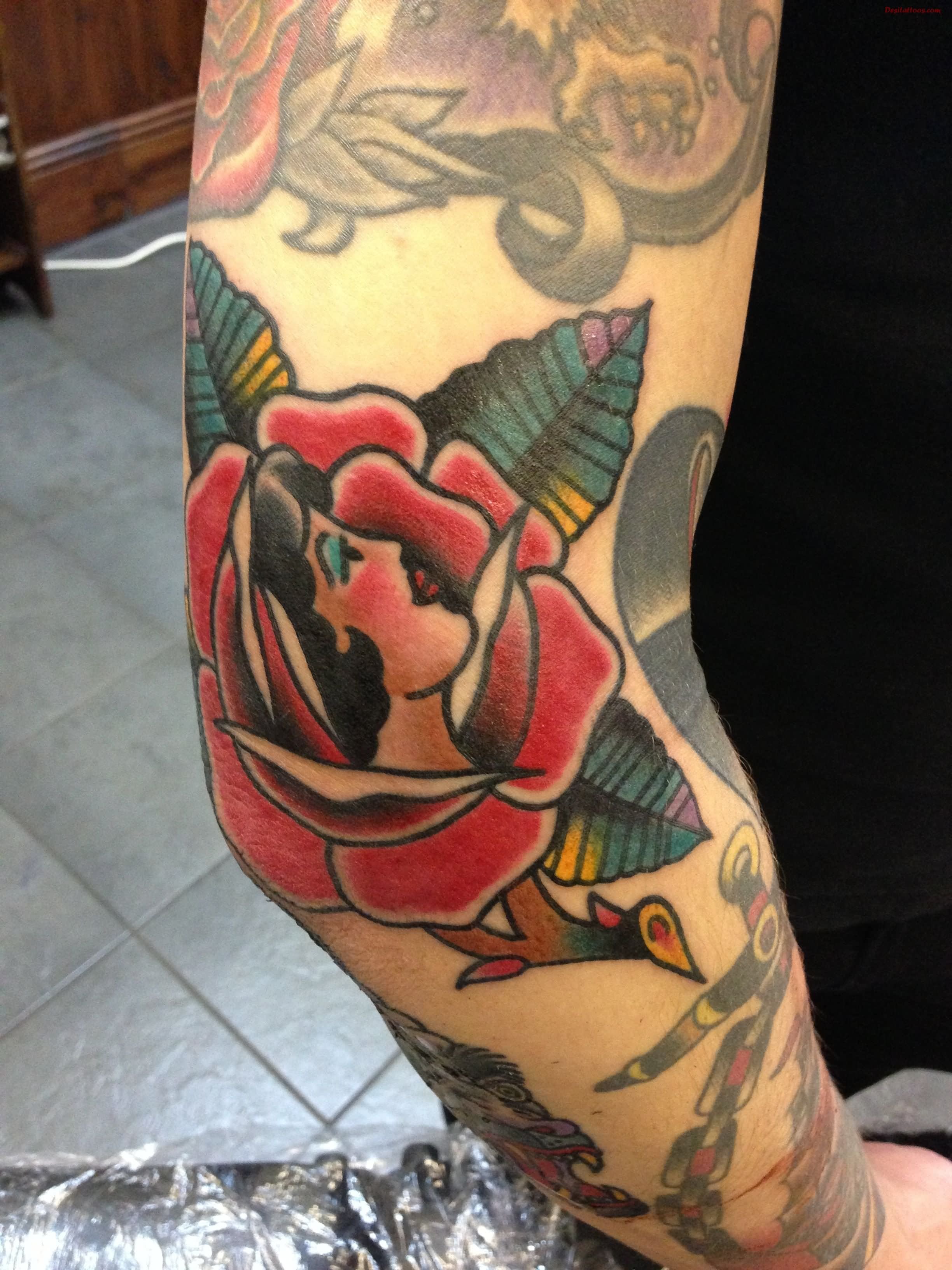 Traditional Girl Face In Rose Tattoo On Right Elbow