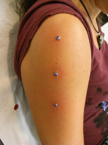 Bicep Piercing With Blue Dermal Anchors