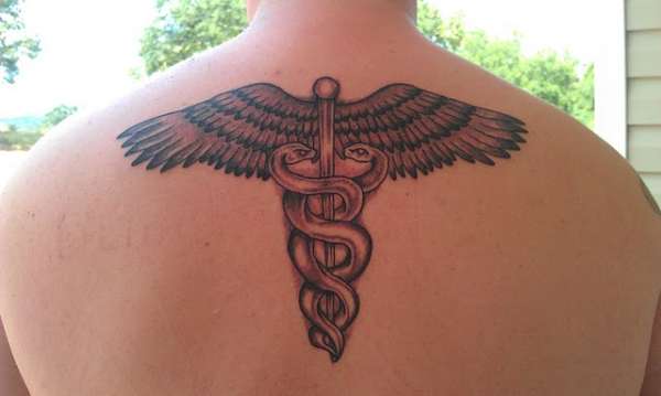 Black Ink Medical Symbol Tattoo On Man Upper Back