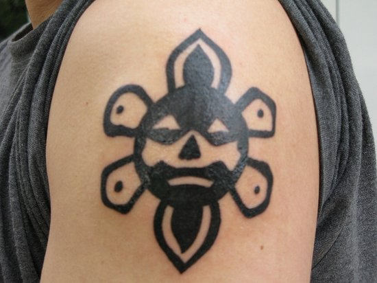 Black Ink Outline Taino Sun Tattoo On Left Shoulder