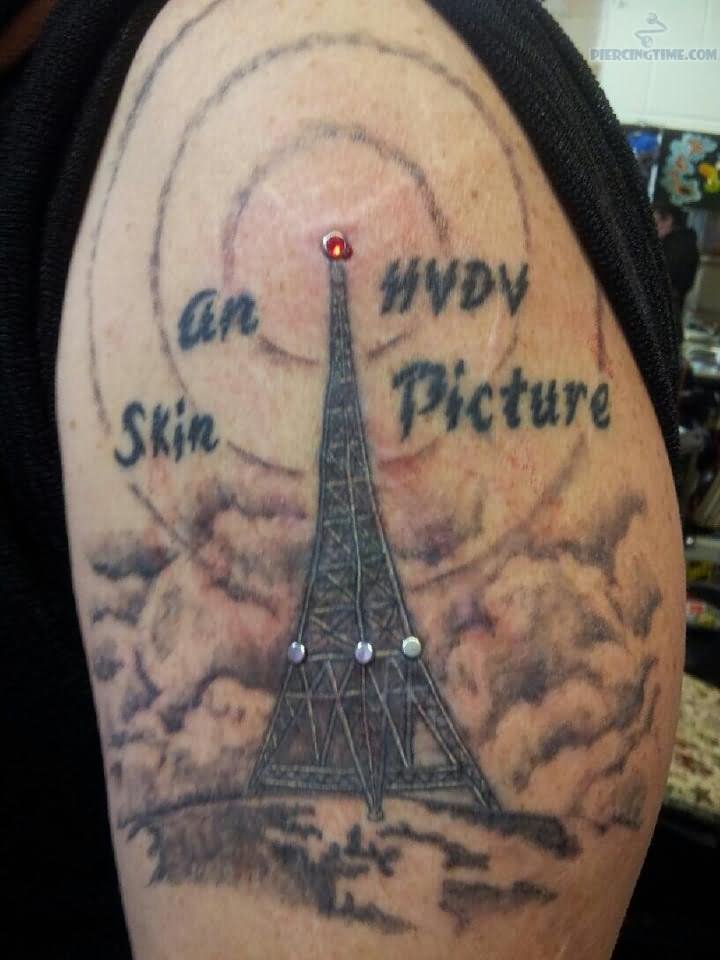 Eiffel Tower Tattoo And Exotic Piercing On Bicep