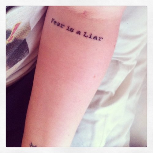 Fear Is A Liar Lettering Tattoo On Inside Elbow