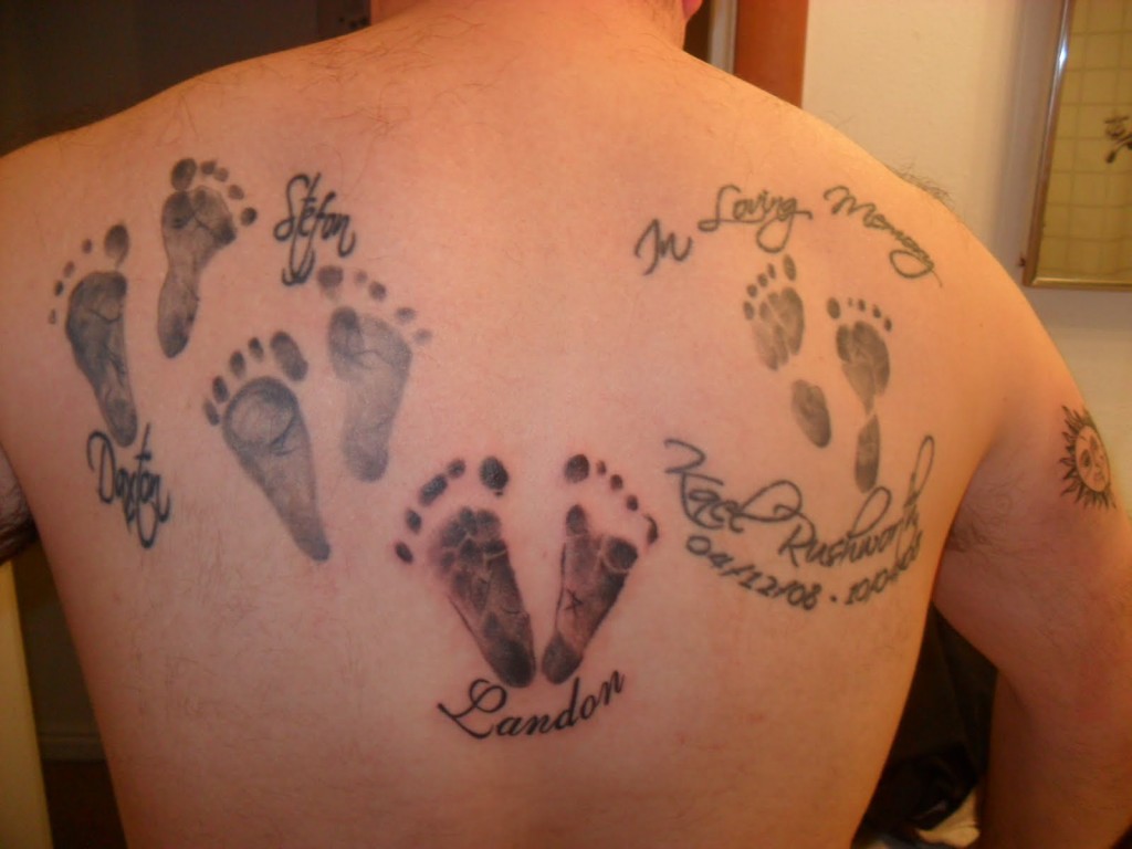 Memorial Black And Grey Feet Prints Tattoo On Upper Back