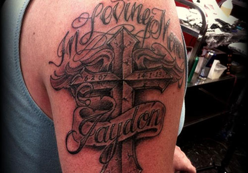 Memorial Black Ink Cross With Banner Tattoo On Right Shoulder