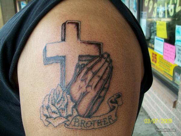 Memorial Cross With Praying Hands And Brother Banner Tattoo On Shoulder