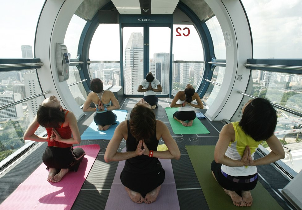 People Take Part In A Yoga Class Inside Capsule Of The Singapore Flyer
