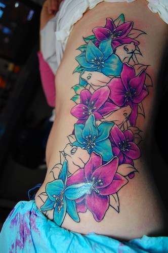 Purple And Blue Floral Tattoo On Girl Side Rib